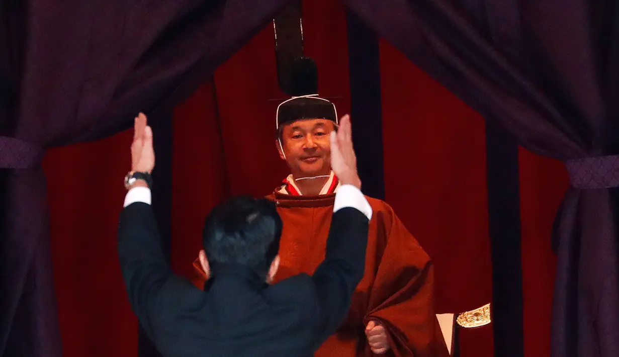 Perdana Menteri Jepang Shinzo Abe mengangkat tangan sambil bersorak 'banzai' kepada Kaisar Naruhito dalam upacara penobatan di Istana Kekaisaran, Tokyo, Jepang, Selasa (22/10/2019). Naruhito resmi menjadi Kaisar Jepang setelah melalui ritual penobatan. (Issei Kato/Pool Photo via AP)