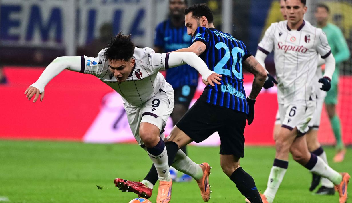 Laga kedua tim berlangsung ketat dan sengit. Inter Milan langsung mengambil alih kendali permainan setelah peluit tanda dimulainya pertandingan dibunyikan. Tampak dalam foto, penyerang Bologna asal Argentina, Santiago Castro (kiri) berebut bola dengan gelandang Inter Milan asal Turki, Hakan Calhanoglu dalam pertandingan pekan ke-17 Serie A Italia di Stadion San Siro, Milan, Minggu (4/1/2026) waktu setempat atau Senin (5/1/2026) dini hari WIB. (Piero CRUCIATTI/AFP)