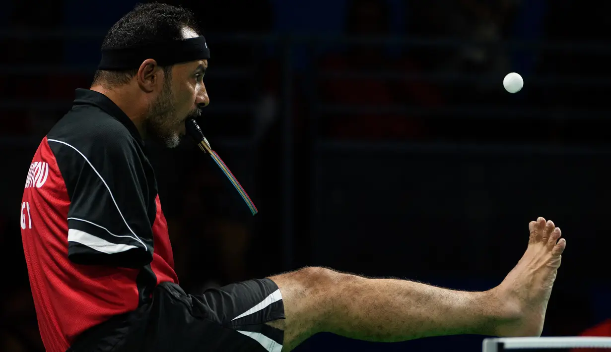 Atlet Mesir, Ibrahim Hamadtou bersiap memukul bola dengan bantuan kakinya saat bertanding melawan atlet Jerman, Thoma Rau pada cabang tenis meja tunggal putra di ajang Paralimpiade 2016, Rio de Janeiro, 9 September 2016. (Thomas Lovelock/OIS/IOC via AFP)