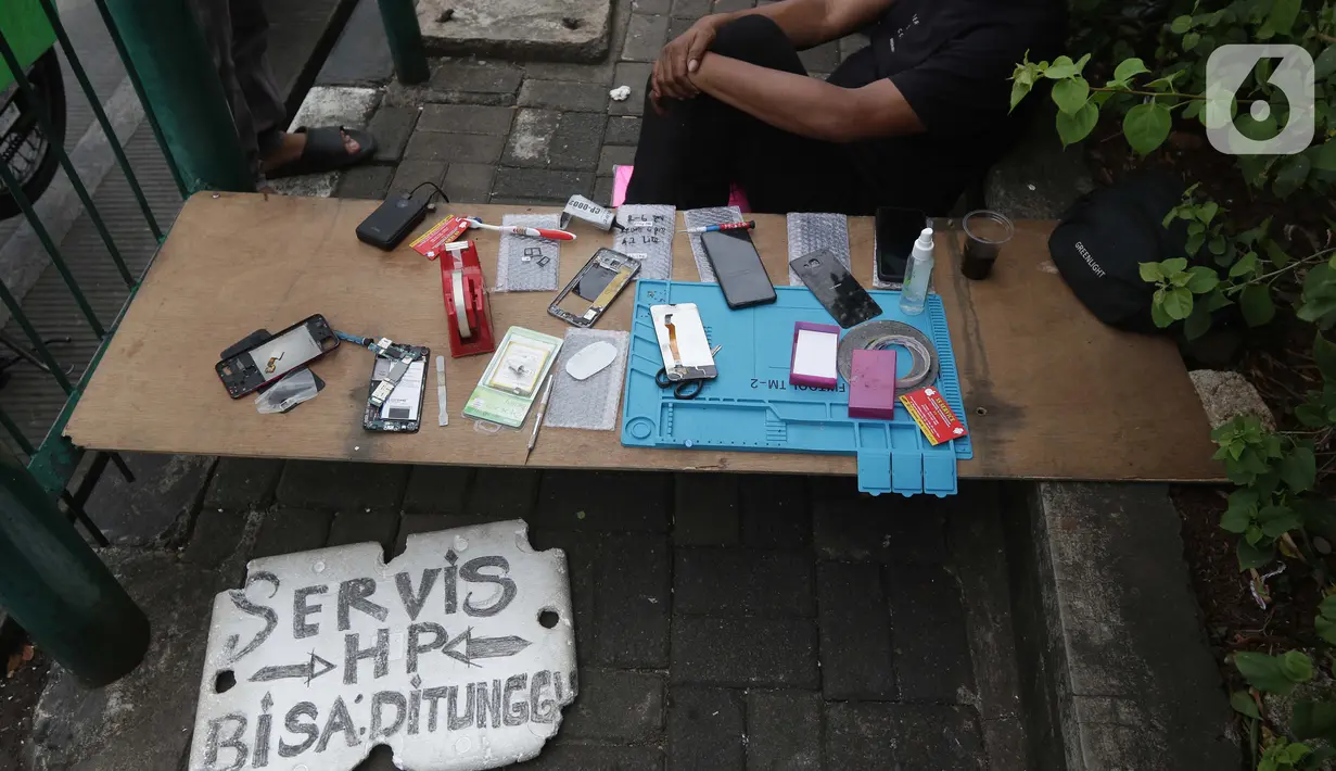 Penjual jasa perbaikan telepon genggam menawarkan jasa di trotoar jalan Mayjen Sutoyo depan Mall Pusat Grosir Cililitan (PGC), Jakarta, Rabu (14/7/2021). Imbas dari penutupan Mall PGC selama PPKM Darurat Jawa-Bali, mereka terpaksa menawarkan jasa di pinggir jalan. (Liputan6.com/Helmi Fithriansyah)