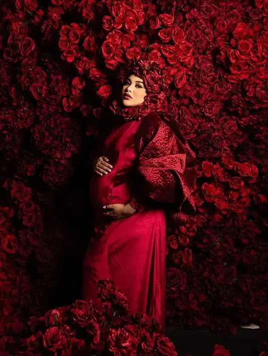 Stylist Erich Al Amin, memilihkan gaun merah dari desainer Julianto, saat maternity shoot anak ke-2, gaun tersebut dipadukan penutup kepala bunga mawar merah. Penampilannya ini menuai sorotan, ada yang mengomentari baik ada pula yang mencibir. [@aurelie.hermansyah]