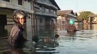 Pekerja yang meninggalkan sepeda motornya di pabrik tempatnya bekerja, nekad menembus banjir rob untuk mengambil sepeda motornya, Selasa (24/5/2022)