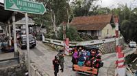 Penduduk desa menggunakan mobil bak terbuka dievakuasi dari rumah mereka di lereng Gunung Merapi, di Krinjing, Jawa Tengah, Jumat (6/11/2020). Evakuasi dilakukan bagi warga lereng Merapi menyusul peningkatan status aktivitas vulkanik gunung tersebut. (AP Photo/Taufiq Rozzaq)