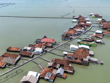 Pemandangan udara menunjukkan rumah-rumah yang sebagian terendam air laut akibat banjir pasang surut di sepanjang pantai selatan Laut Jawa di desa Timbulsloko, Demak, Jawa Tengah pada Sabtu 18 April 2026. Desa Timbulsloko di Sayung, Demak, Jawa Tengah kembali terendam banjir rob (pasang surut) ekstrem. (DEVI RAHMAN/AFP)