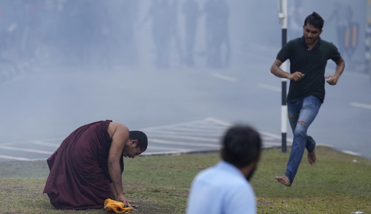 Seorang biksu Buddha Sri Lanka bereaksi setelah menghirup gas air mata yang digunakan oleh polisi untuk membubarkan protes anti-pemerintah oleh mahasiswa Sri Lanka menuntut pengunduran diri presiden Gotabaya Rajapaksa di dekat parlemen di Kolombo, Sri Lanka (8/4/2022). (AP Photo/Eranga Jayawardena)
