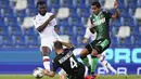 Pemain AC Milan Franck Kessie (kiri) dan pemain Sassuolo Rogerio (kanan) berebut bola pada pertandingan Serie A Italia di Stadion Mapei, Reggio Emilia, Italia, Selasa (21/7/2020). AC Milan menang 2-1 sekaligus menggeser posisi AS Roma dari posisi lima klasemen. (Spada/LaPresse via AP)