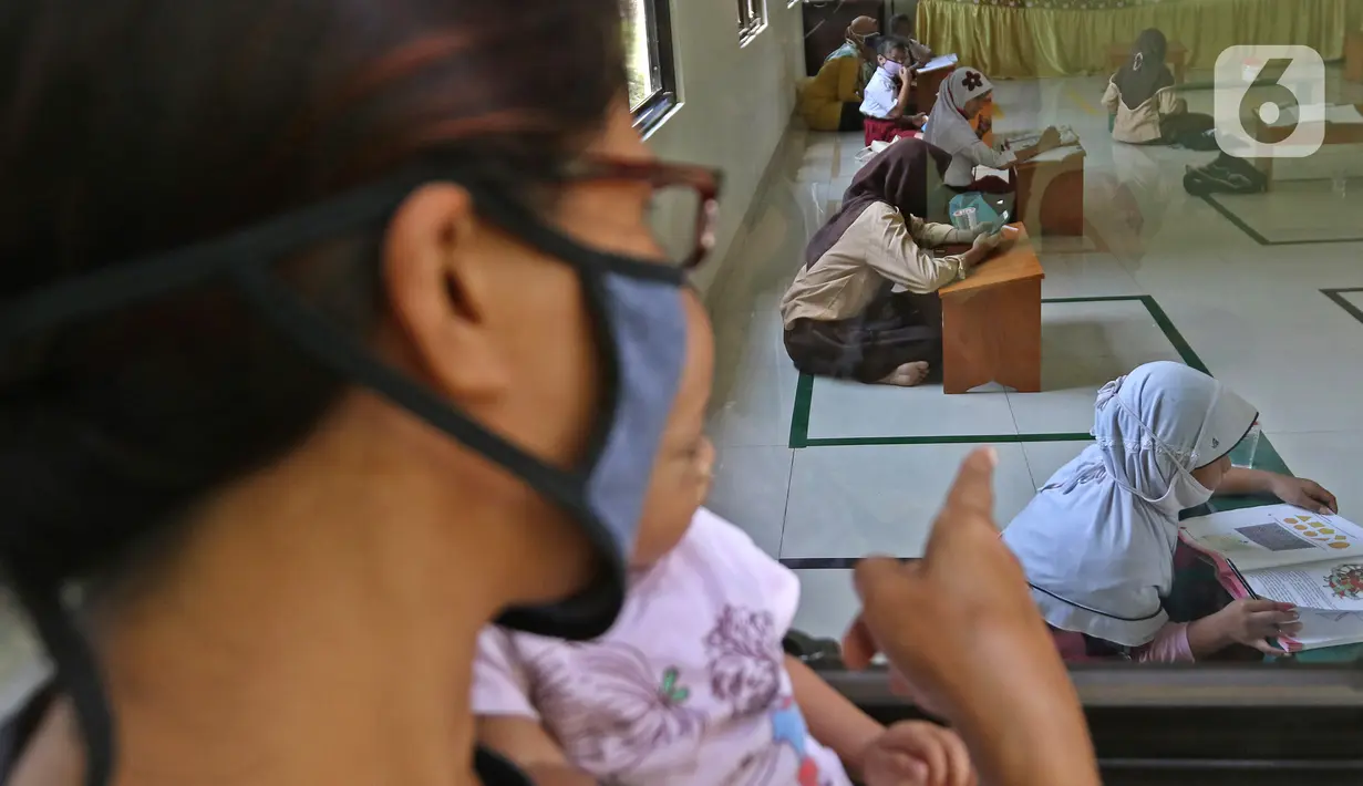 Sejumlah siswa belajar di Aula Kelurahan Jatirahayu, Bekasi, Jawa Barat, Rabu (29/7/2020). Pemerintah Kota Bekasi melalui Kelurahan Jatirahayu menyediakan fasilitas wifi gratis bagi siswa yang terkendala kuota internet dalam kegiatan belajar secara daring. (Liputan6.com/Herman Zakharia)
