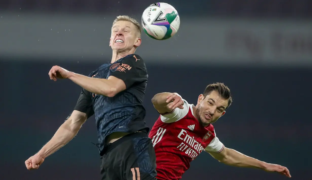 Gelandang Manchester City, Oleksandr Zinchenko dan bek Arsenal, Cedric Soares berebut bola pada laga perempatfinal Piala Liga Inggris di Emirates Stadium, Rabu (23/12/2020) dini hari WIB. Man City melenggang ke semifinal Piala Liga Inggris lewat kemenangan 4-1 atas Arsenal. (AP Photo/Frank Augstein)
