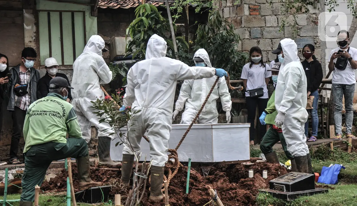 Proses pemakaman pasien Covid-19 isolasi mandiri di TPU Pondok Kelapa, Jakarta, Selasa (13/7/2021). Para pasien isolasi mandiri ini meninggal karena berbagai alasan, mulai dari terlambat mendapatkan pertolongan, rumah sakit penuh hingga tidak terpantau dengan baik. (merdeka.com/Iqbal S Nugroho)