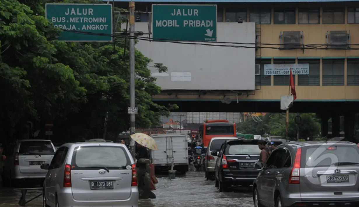 Intensitas curah hujan yang tinggi sejak Minggu (8/2) membuat Sungai Pesanggrahan meluap. Laju kendaraan tersendat karena  ketinggian air 20cm menggenangi sebagian ruas jalan di Pasar Cipulir, Jakarta, Selasa (10/2/2015).(Liputan6.com/Andrian M Tunay)