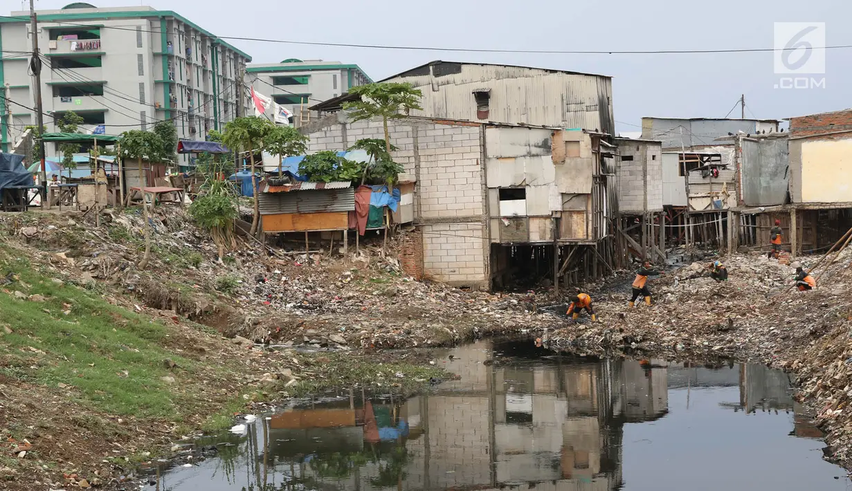 Petugas membersihkan sampah yang memenuhi aliran Kali Gendong di kawasan Penjaringan, Jakarta, Senin (3/12). Penumpukan sampah akibat tidak tersedianya tempat pembuangan. (Liputan6.com/Immanuel Antonius)