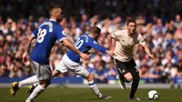 Gelandang Manchester United, Nemanja Matic, berusaha melewati pemain Everton pada laga Premier League di Goodison Park, Minggu (21/4). Everton menang 4-0 atas Manchester United. (AFP/Oli Scarff)