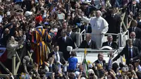 Minggu (20/4/2014), usai Misa Paskah, Paus Fransiskus menyapa kerumunan umat yang hadir di Lapangan Santo Petrus. (AFP PHOTO/ANDREAS SOLARO) 