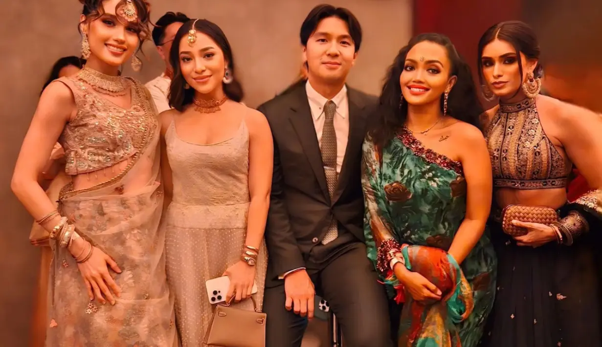 Cinta Laura mengenakan lehenga model atasan crop sleeveless warna coklat dihiasi beads senada dengan rok panjangnya. Tak lupa dengan selendangnya. Rambutnya ditata kuncir belakang bergaya wavy dengan hiasan patti atau perhiasan dahi senada dengan anting-anting, kalung hingga gelangnya. [@nikitawillyofficial94]