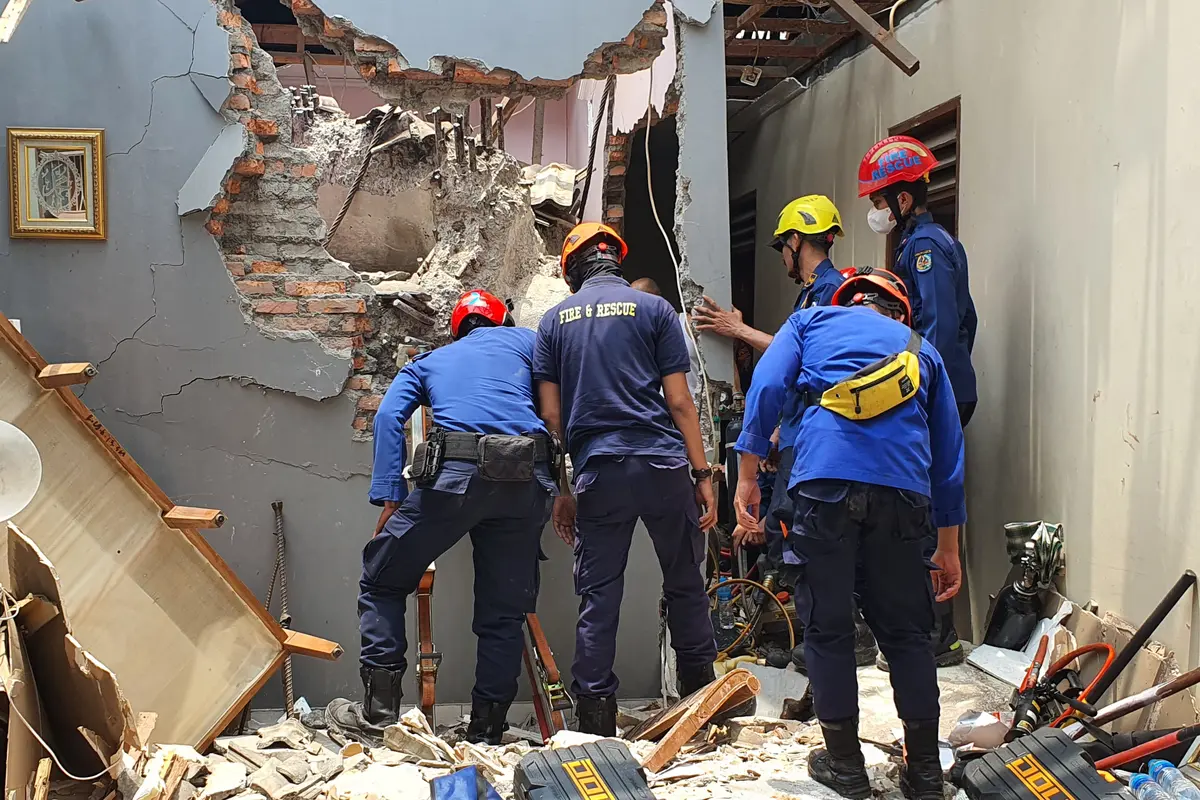 Petugas gabungan masih mengevakuasi korban terjepit reruntuhan akibat crane dan menara air PDAM yang runtuh menimpa rumah warga di Jalan Mawar, Kelurahan Depok Jaya, Kecamatan Pancoran Mas, Kota Depok.