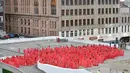 Ratusan orang berpose mengenakan kain merah transparan saat foto bugil massal dari proyek terbaru fotografer AS Spencer Tunick di tempat parkir mobil di pusat perbelanjaan di Melbourne, Australia (9/7). (AFP Photo/Paul Crock)