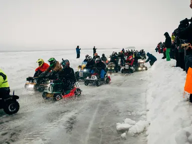 Peserta berkompetisi dalam kejuaran balap mesin potong rumput tahunan di Lavia, Finlandia, 9 Februari 2019. Para pembalap harus menyelesaikan sebanyak mungkin putaran di area pertandingan yang tertutup salju. (Alessandro RAMPAZZO/AFP)