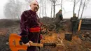 Seorang seniman yang berpakaian Cossack memegang gitarnya usai tampil untuk tentara Garda Nasional Ukraina saat memperingati Natal dekat perbatasan Rusia di Kharkiv, Ukraina, 24 Desember 2022. Pasukan pertahanan Ukraina telah memukul mundur serangan Rusia dekat 19 permukiman di wilayah seperti Sumy, Kharkiv, Donetsk, dan Luhansk selama beberapa hari terakhir. (AP Photo/Andrii Marienko)
