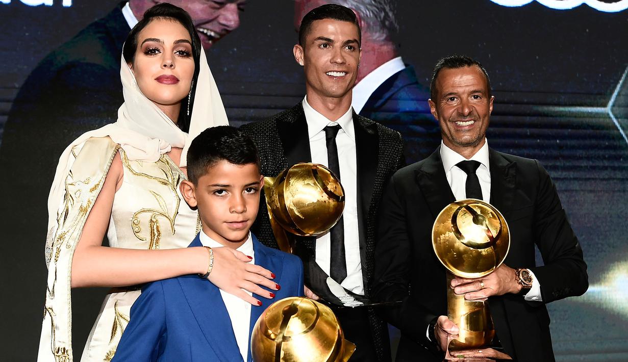 Georgina Rodriguez foto bersama kekasihnya Cristiano Ronaldo, putranya Cristiano Jr dan agen, Jorge Mendes diatas panggung selama Dubai Globe Soccer Awards ke-10 di Dubai (3/1). (AFP Photo/Fabio Ferrari)