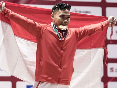 Lifter Indonesia, Eko Yuli Irawan, melakukan selebrasi usai berlaga pada Asian Games di JIExpo, Jakarta, Selasa, (21/8/2018). Eko Yuli berhasil menyumbang medali emas angkat besi putra kelas 62kg. (Bola.com/Peksi Cahyo)