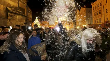 Warga saat melakukan flash mob perang bantal selama empat menit di Old Town Square di Praha,Ceko (22/12). flash mob perang bantal ini dilakukan jelang pergantian akhir tahun. (REUTERS/ David W Cerny)