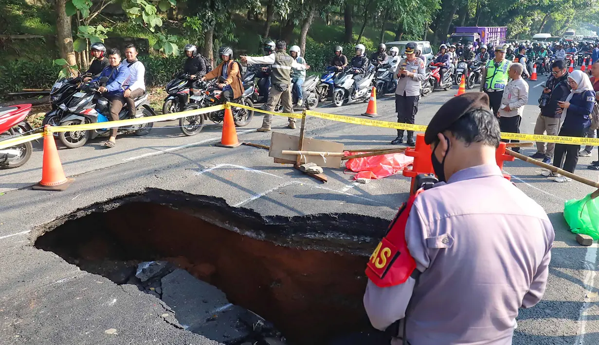 Pengendara melintas di sisi ruas jalan yang ditutup sebagian akibat amblas di Jalan Raya Lenteng Agung, Jakarta Selatan, Jumat (29/5/2026). (merdeka.com/Arie Basuki)