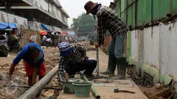 Para pekerja saat melakukan revitalisasi saluran air di kawasan Pasar Kramatjati, Jakarta, Jumat (23/10/2015). Hampir seluruh atap di lantai satu dan dua pasar ini sudah rusak dan keropos. (Liputan6.com/Yoppy renato)