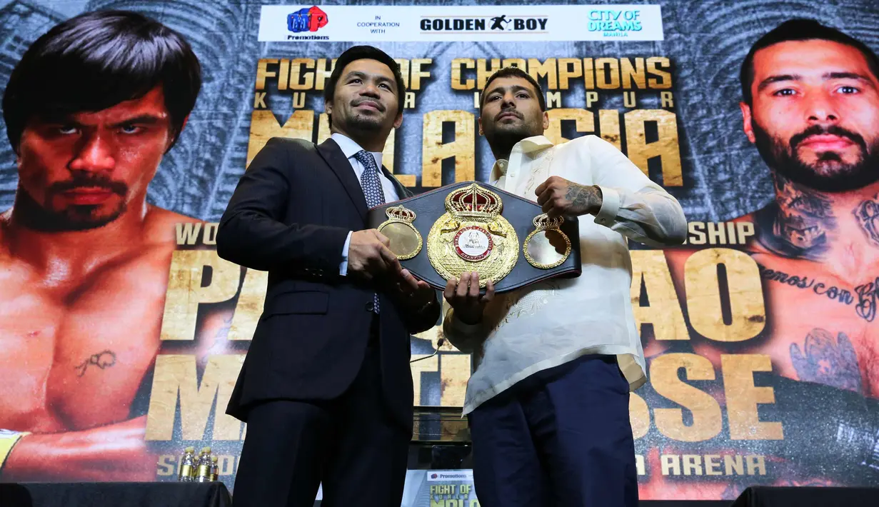 Petinju Manny Pacquiao dan Lucas Matthysse berpose dengan sabuk juara kelas welter WBA selama konferensi pers di Manila, Filipina (18/4). Keduanya dijadwalkan bertarung 15 Juli. (AP Photo/Aaron Favila)