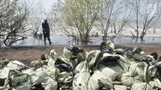 Pegawai Pertamina melintas di depan tumpukkan karung berisi limbah tumpahan minyak (oil spill) di Pantai Muara Beting, Muara Gembong, Bekasi, Jawa Barat, Minggu (28/7/2019). Oil spill akibat kebocoran terjadi di sumur lepas pantai YYA1 Karawang. (merdeka.com/Iqbal S. Nugroho)