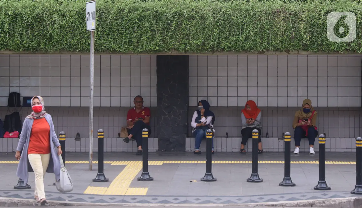 Sejumlah masyarakat melakukan jaga jarak aman di area publik di kawasan Thamrin, Jakarta, Rabu (18/3-2020). Jaga jarak atau prosedur social distancing measure harus diterapkan kepada masyarakat yang masih melakukan aktivitas di luar untuk memghindari penyebaran Covid-19. (Liputan6.com/Angga Yuniar)