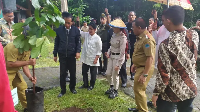 Ibu Negara Iriana payungi Jokowi saat menanam pohon