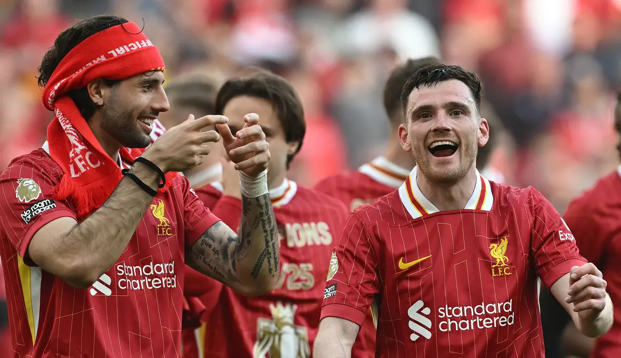 Pemain Liverpool, Dominik Szoboszlai (kiri) merayakan kemenangan timnya bersama Andrew Robertson setelah laga lanjutan Liga Inggris 2024/2025 melawan Tottenham Hotspur di Anfield, Liverpool, Inggris, Minggu (27/04/2025) waktu setempat. (AFP/Paul Ellis)