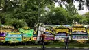 Pekerja menaruh karangan bunga untuk almarhum Sukamdani Sahid di sekitar pinggir Jalan Imam Bonjol, Jakarta, Kamis (21/12). Upacara militer almarhum Sukamdani dilaksanakan di Pondok Pesantren Modern Sahid, Bogor. (Liputan6.com/Immanuel Antonius)