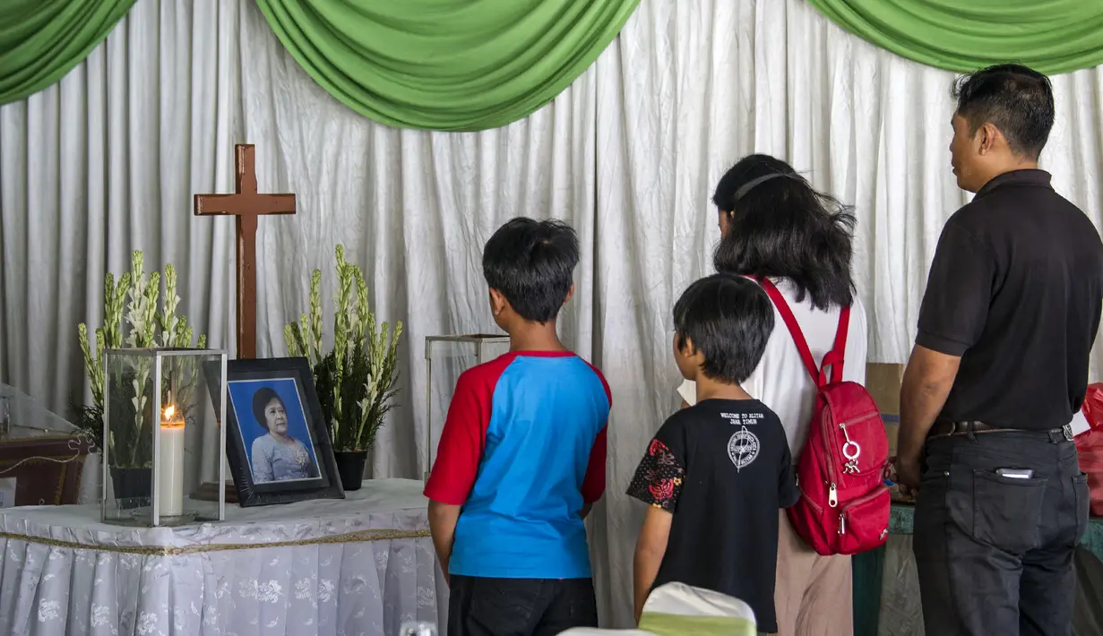 Kerabat memberi penghormatan terakhir kepada Sri Puji, salah satu korban meninggal dalam serangan Gereja Pantekosta, Surabaya, Jawa Timur, Senin (14/5). Serangan bom yang melanda tiga gereja di Surabaya menewaskan belasan orang. (AFP PHOTO/JUNI KRISWANTO)