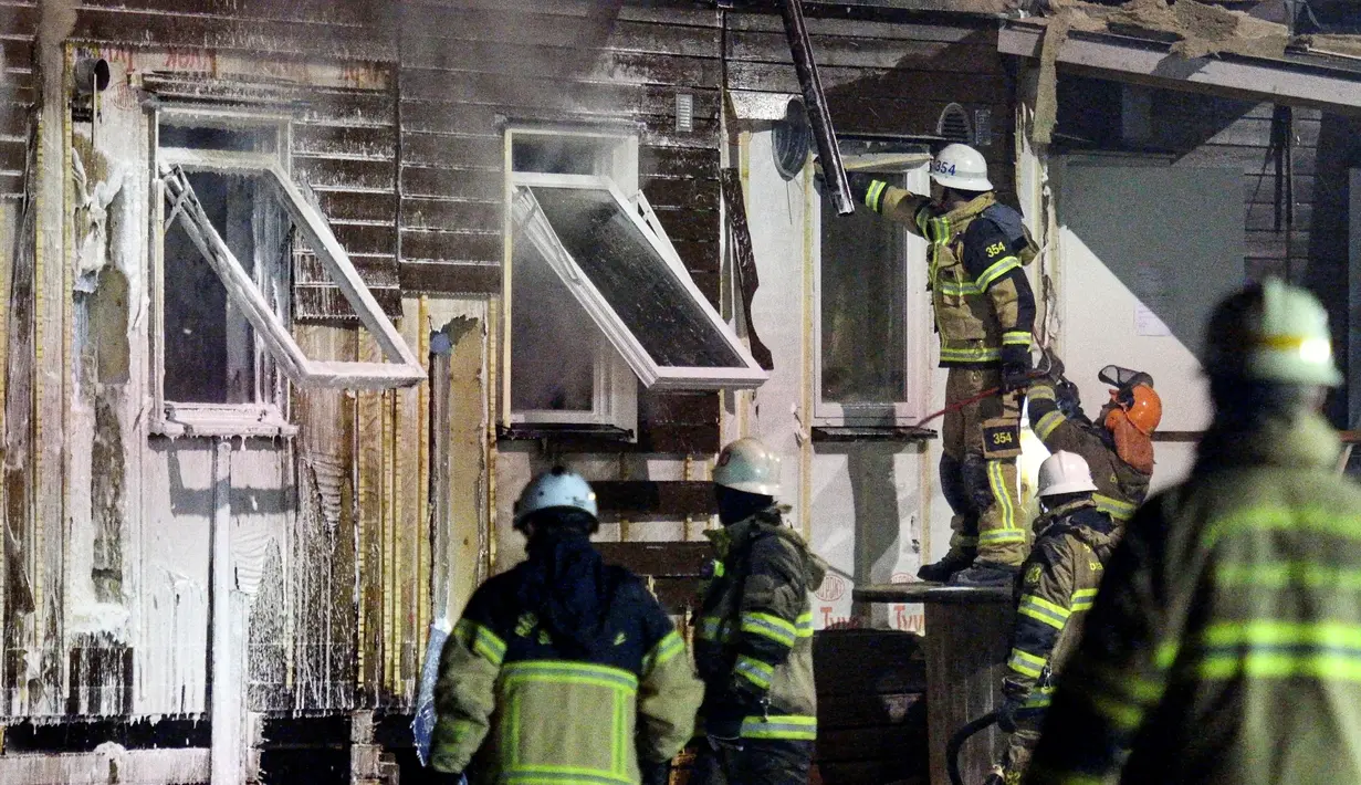 Petugas pemadam kebakaran mengecek tempat pengungsi di Fagersjo yang terbakar, Stockholm, Swedia pada Minggu (16/10) malam. (REUTERS/TT News Agency / Johan Nilsson)