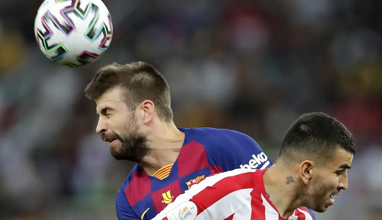 Bek Barcelona, Gerard Pique menyundul bola melewati pemain Atletico Madrid Angel Correa pada laga semifinal Piala Super Spanyol di King Abdullah Sports City, Jeddah, Kamis (9/1/2020). Barcelona harus menjalani pertandingan yang dramatis saat kalah 2-3 dari Atletico Madrid. (AP/Hassan Ammar)