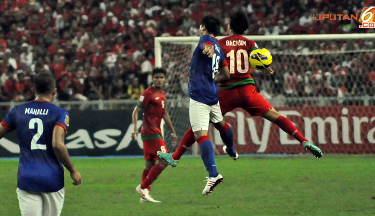 Pemain Indonesia, Irfan Bachdim duel di udara dengan pemain Malaysia dalam Laga Piala AFF Suzuki 2012 antara Malaysia vs Indonesia di Stadion Bukit Jalil, Kuala Lumpur, Malaysia. pertandingan berakhir dengan skor 2-0 untuk Malaysia.