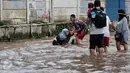 Wanita yang terperosok dalam lubang ditolong oleh warga yang kebetulan melintas di kawasan Bukit Duri saat dilanda banjir, Jakarta, Selasa (21/2). (Liputan6.com/Yoppy Renato)