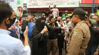 Pedagang di PGC Kota Cirebon menghalau petugas Gugus Tugas Percepatan Penanganan Covid-19 saat sedang memberi imbauan untuk tidak berjualan. Foto (Liputan6.com / Panji Prayitno)