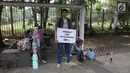 Koalisi Pejalan Kaki menunjukkan poster yang berisi imbauan saat melakukan aksi Tamasya Trotoar Kita di Jalan Medan Merdeka Selatan, Jakarta, Minggu (24/6). (Liputan6.com/Arya Manggala)