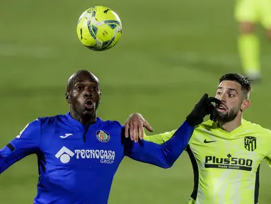 Pemain Atletico Madrid, Yannick Carrasco, duel udara dengan pemain Getafe, Allan Nyom, pada laga Liga Champions di Stadion Alfonso Perez, Sabtu (13/3/2021). Kedua tim bermain imbang 0-0. (AP/Manu Fernandez)
