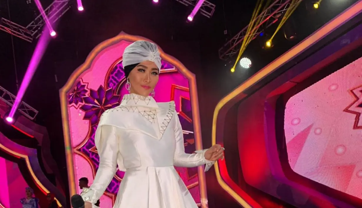 Inul Daratista saat berada di panggung. Inul tampil sangat modis dengan balutan busana putih dilengkapi dengan turban berwarna putih juga. Dengan memakai turban hijab warna putih, pesona Inul sangat terpancarkan (Instagram.com/Inul.d)