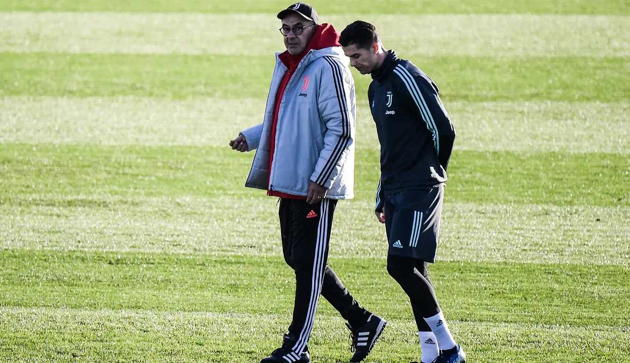 Pelatih Juventus Maurizio Sarri sambil berjalan berbincang dengan penyerang Cristiano Ronaldo sesi latihan di Continassa Training Ground di Turin (25/11/2019). Ronaldo dan Sarri telah bertemu membereskan insiden yang terjadi agara tidak memengaruhi kondisi internal tim. (AFP/Marco Bertorello)