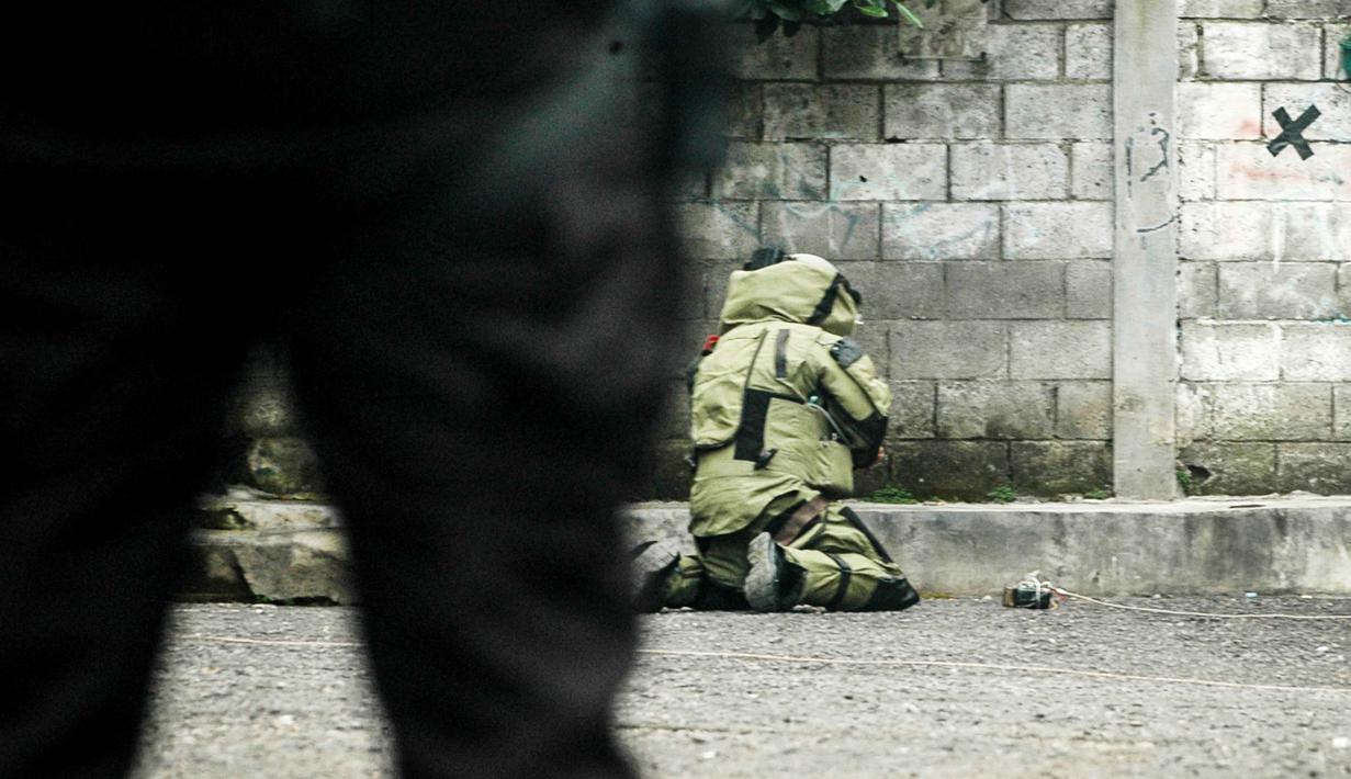 Dari hasil pemeriksaan tim penjinak bom Brimob Polda Jawa Barat, benda itu bukan bahan peledak, melainkan kayu. Tampak dalam foto, seorang petugas polisi dari unit penjinak bom memeriksa sebuah benda mencurigakan berbentuk kotak yang dibungkus lakban hitam dengan kabel di depan Gereja Kristen Protestan Simalungun (GKPS) di Bandung, Jawa Barat pada 19 Desember 2025. (Timur Matahari/AFP)
