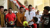 Menpora Imam Nahrawi (tiga dari kiri) didampingi perenang Indonesia, Siman Sudartawa (baju putih) membagikan bola kepada anak-anak pengungsi erupsi Gunung Agung di Klungkung, Bali, Sabtu (30/9/2017). (Humas Kemenpora) 