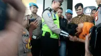 Pelanggar lalu lintas, Adi Saputra (21) yang merusak kendaraannya saat ditilang polisi, menangis di Polres Tangerang Selatan. (Liputan6.com/Pramita Tristiawati)