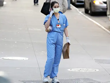 Pekerja medis tiba untuk shiftnya di RS NewYork-Presbyterian/Weill Cornell Medical Center selama pandemi COVID-19 di New York City (21/4/2020). COVID-19 telah menyebar ke sebagian besar negara di dunia, lebih dari 175.000 jiwa dengan infeksi lebih dari 2,5 juta orang. (Cindy Ord/Getty Images/AFP)