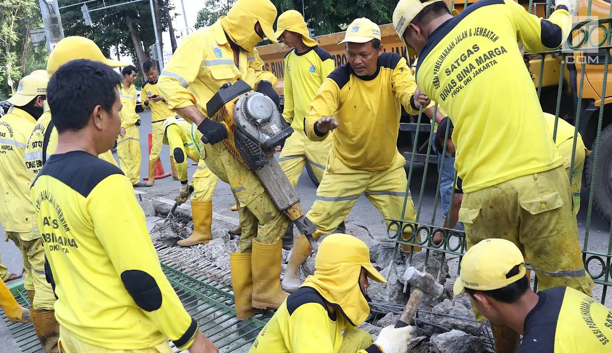 Petugas Dinas Bina Marga membongkar pagar dan sepatator di Jalan Galunggung, Jakarta, Kamis (10/1). Pembongkaran dilakukan guna menghilangkan batas antar jalur sehingga diharapkan dapat mengurai simpul kemacetan. (Liputan6.com/Immanuel Antonius)