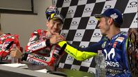 Valentino Rossi dan Jorge Lorenzo saling berjabat tangan pada sesi konferensi pers MotoGP Italia, Minggu (3/6/2018). (Twitter/MotoGP)