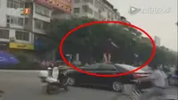 Hampir celaka, wanita memutuskan untuk menari di atas mobil. (Shanghaiist)